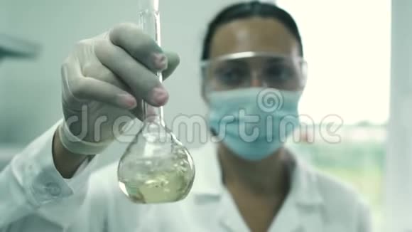 女实验室的助手在瓶子里搅拌液体视频的预览图