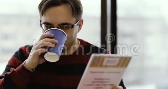 一个留胡子的商人喝咖啡在咖啡馆里读菜单视频的预览图