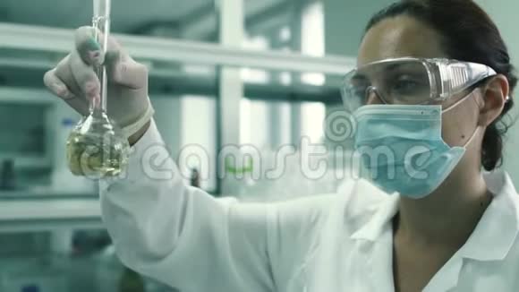 漂亮的实验室技术人员用化学液体把烧瓶剥开视频的预览图