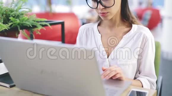 一个女人在工作场所接一个打进来的电话视频的预览图