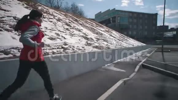 年轻女子在晴朗的冬天在公园里跑步视频的预览图