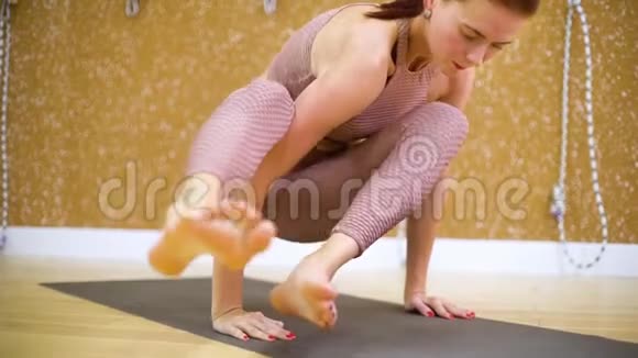 在慢动作瑜伽课中做瑜伽体式的年轻女性视频的预览图