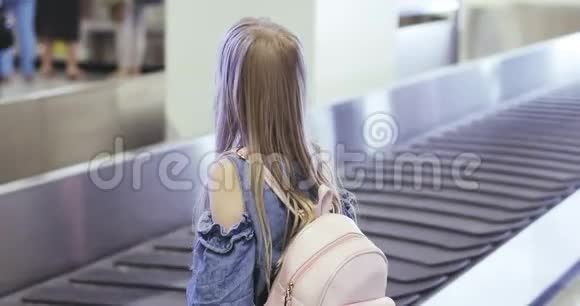 一个金发小女孩在机场等她的行李视频的预览图