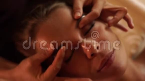 在美容院接受皮肤按摩的年轻女性特写肖像女士在化妆品中接受面部按摩视频的预览图
