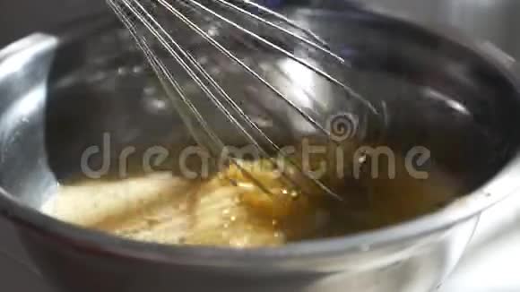 女孩在玻璃碗里用糖搅拌生鸡蛋吹着鸡蛋视频的预览图