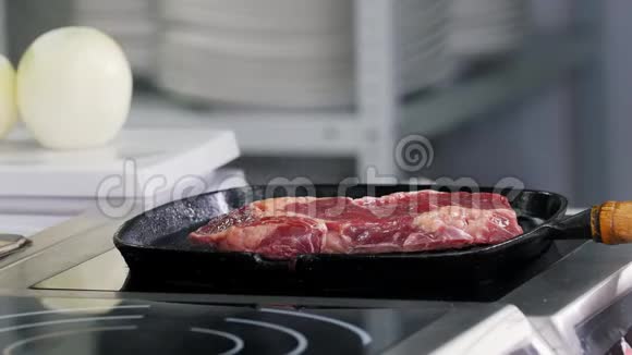 在厨房工作厨师开始在锅里煎牛排视频的预览图