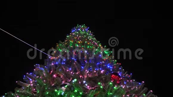 美丽的高大的圣诞杉树装饰着花环和多种颜色的球对夜空小小的雪视频的预览图