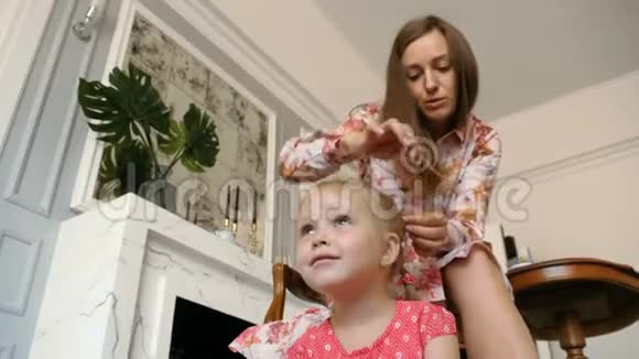 一个漂亮的女人编她小女儿的辫子视频的预览图