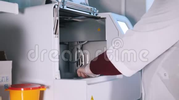 医疗诊所护士从机器上取血样视频的预览图
