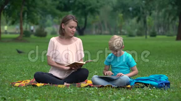 妈妈看书儿子用平板电脑用IT技术替代教育视频的预览图