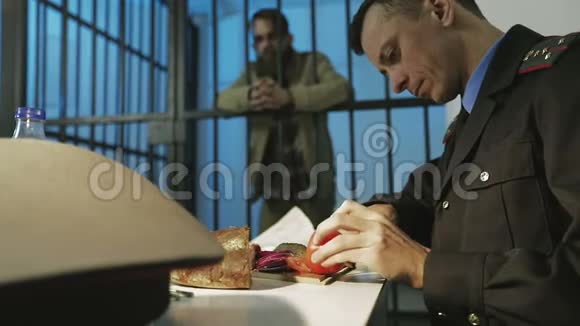 一名俄罗斯警察在办公室切了一个西红柿并做午餐视频的预览图