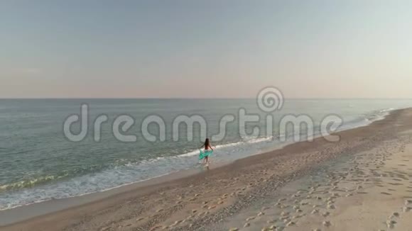 日落时一个女人在海边散步的美丽场景快乐快乐的女孩放松表现出快乐和幸福视频的预览图