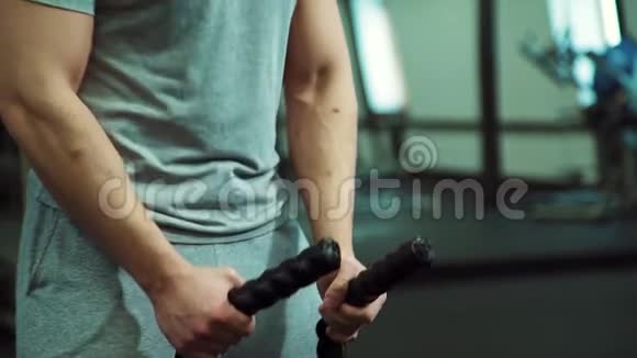 在健身房交叉健身男子拿着两根绳子进行力量锻炼视频的预览图