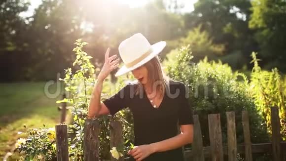 戴帽子的女人在夏天的乡村花园视频的预览图