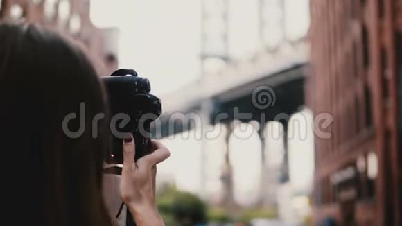 后景女旅行博主带相机拍摄布鲁克林大桥在Dumbo纽约市走开4K视频的预览图