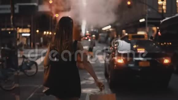 年轻漂亮的女人带着购物袋走在美国纽约市中心穿过交通道路视频的预览图