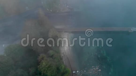头顶拍摄的木船码头附近常绿森林被雾包围视频的预览图