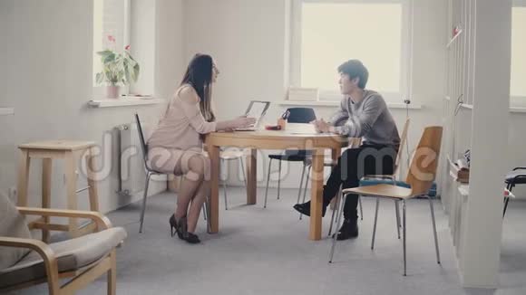 镜头放大白种人女高管与年轻的亚洲员工交谈4K阁楼办公室的不同商务人员视频的预览图