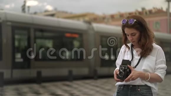 迷人的女摄影师用老式相机拍摄法国尼斯的视频视频的预览图