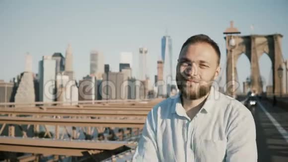 成功的快乐白人商人横过手臂的肖像在纽约布鲁克林大桥的镜头前微笑视频的预览图