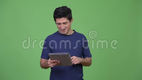西班牙裔快乐男子视频电话与数字平板电脑视频的预览图