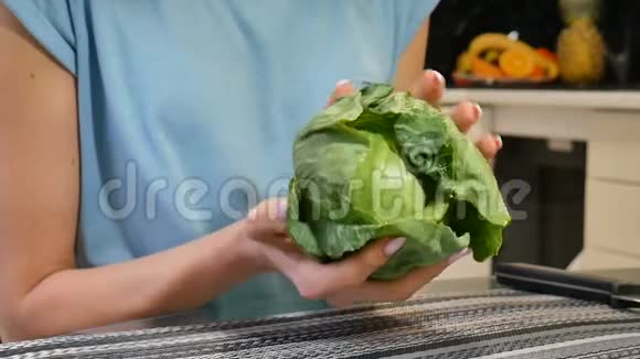 在厨房里用绿色的卷心菜把雌性的手收起来均衡的饮食观念视频的预览图