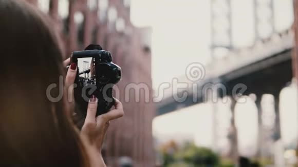 后景不可辨认的妇女与相机拍摄布鲁克林大桥在纽约Dumbo区4K视频的预览图