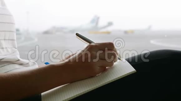 年轻女子在机场写日记特写视频的预览图