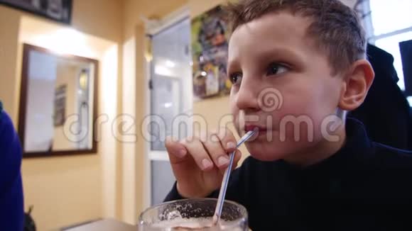 一个男孩正在用吸管喝奶昔特写镜头视频的预览图