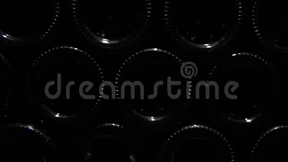 酒窖里一堆酒瓶的特写镜头存放在石头木架中的玻璃瓶红酒视频的预览图