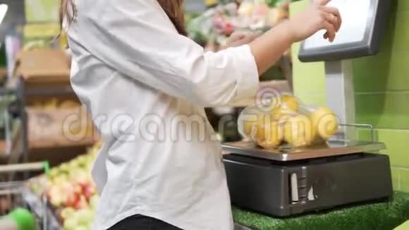 一个穿白色衬衫的女人在商店里用橘子秤视频的预览图