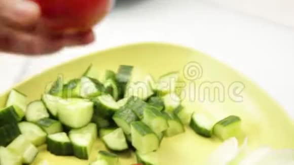 女人在厨房桌子上切番茄做沙拉或凉拌菜烹调蔬菜中的健康食物视频的预览图