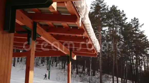 融化的冰柱从屋顶上滴落下来春滴冰柱正在融日雪春天在滑雪场视频的预览图