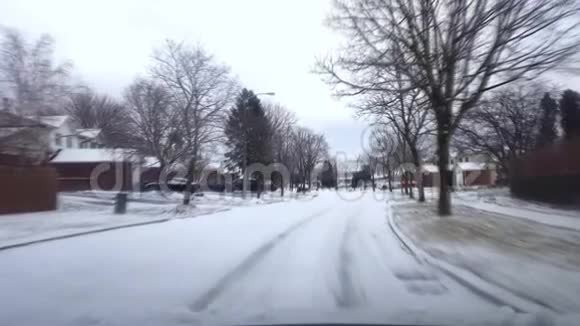 在有运动模糊效应的日子里驾驶覆盖雪的住宅郊区街视频的预览图
