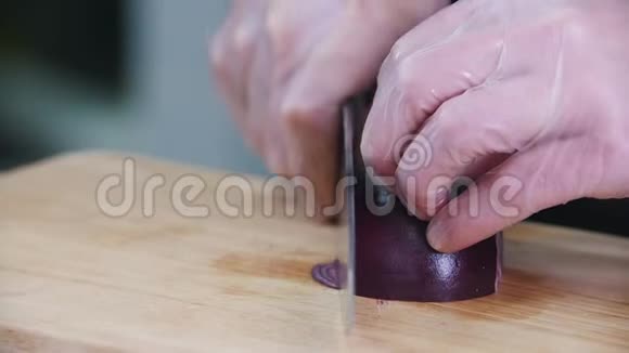 在厨房工作的厨师切一个红洋葱视频的预览图