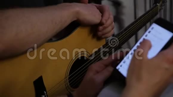 特写双手练习弹吉他双手拿着手机慢动作视频的预览图
