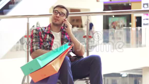 一个残疾人坐在轮椅上购物后在购物中心打电话玩得很开心关门视频的预览图