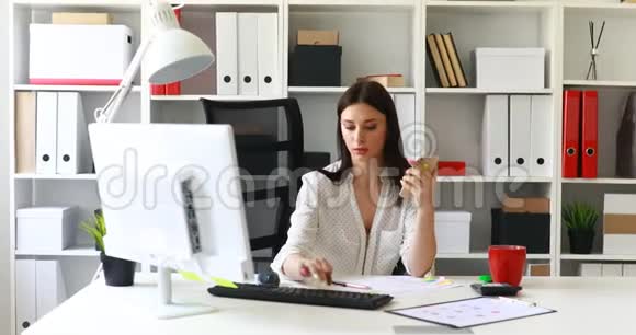 在电脑前工作在办公室里使用智能手机的女商人视频的预览图