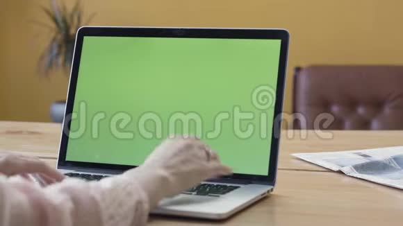 用绿色屏幕的笔记本电脑观看女性双手的肩膀库存录像女性手在笔记本电脑上打字视频的预览图