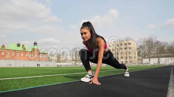 亚洲运动员年轻女孩准备开始在体育场视频的预览图