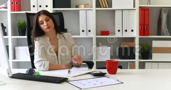 一个疲惫的女商人手放在头上坐在办公桌旁视频的预览图