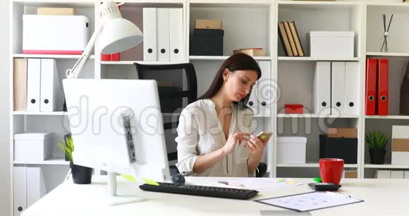 坐在办公椅上使用智能手机的女商人视频的预览图