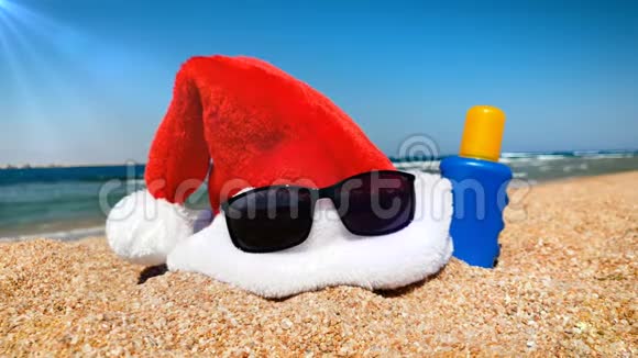 4k视频中的圣诞帽太阳镜和防晒霜躺在沙滩上过冬的概念视频的预览图