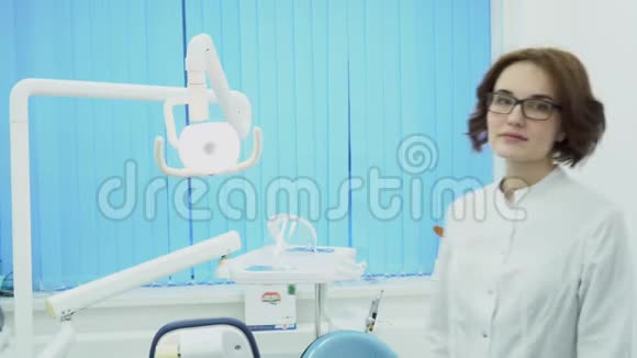 女牙医见到客户微笑媒体穿白色外套的女牙医欢迎牙科办公室的新客户牙科视频的预览图