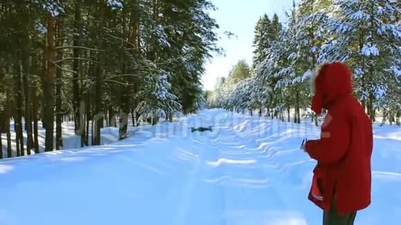 年轻人在冬季森林里控制飞行无人机视频的预览图