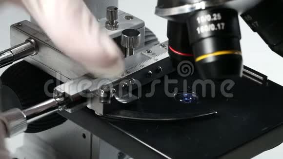 研究人员或科学家在显微镜下将标本放置在样品架上视频的预览图