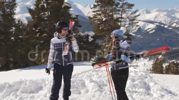 一双手拿着滑雪板的滑雪者爬到山顶视频的预览图