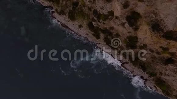鸟瞰汹涌的海浪拍打陡峭的悬崖视频的预览图