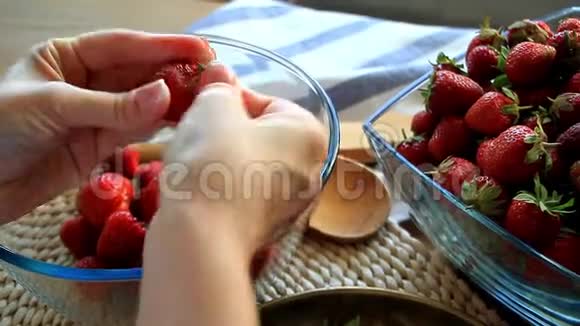 双手合拢剥下新鲜的大草莓供以后使用视频的预览图