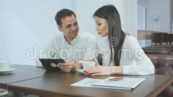 兴奋的女人在咖啡休息时给她的男同事讲故事视频的预览图